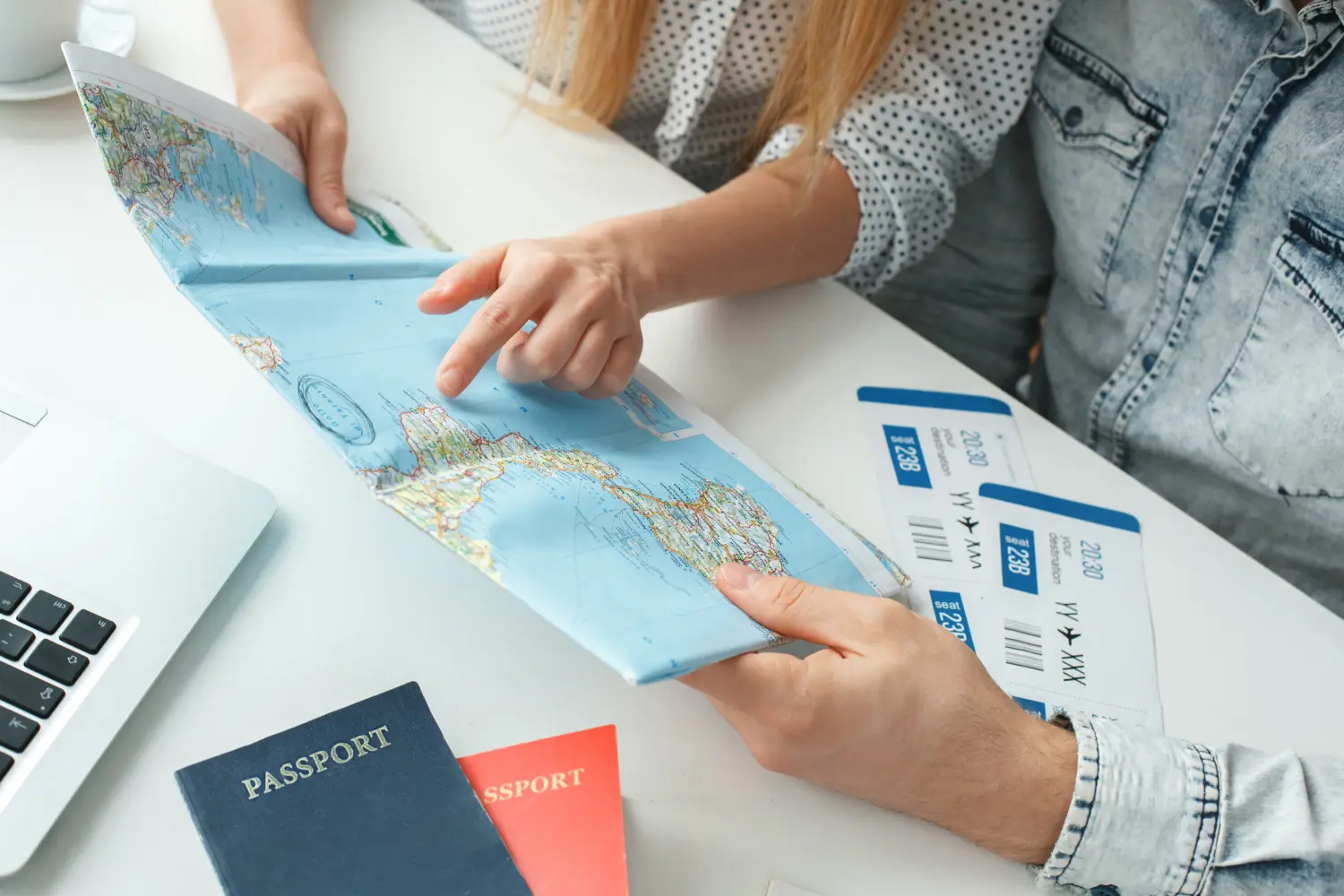 Junges Paar in einem Reisebüro – Reisekonzept bei der Auswahl eines Reiseziels (Nahaufnahme).